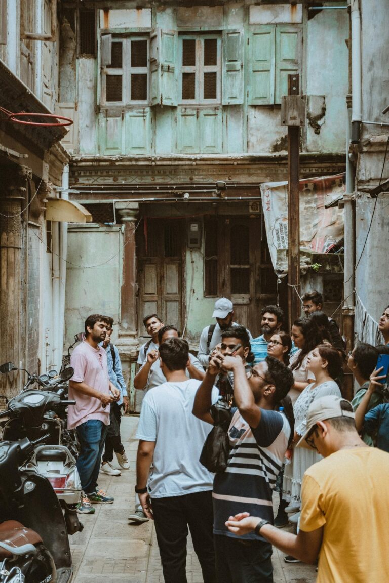 Tourists gathered in an old alleyway in Ahmedabad, India, learning about local history.